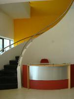 the reception desk on the ground floor and the curved stair leading up.